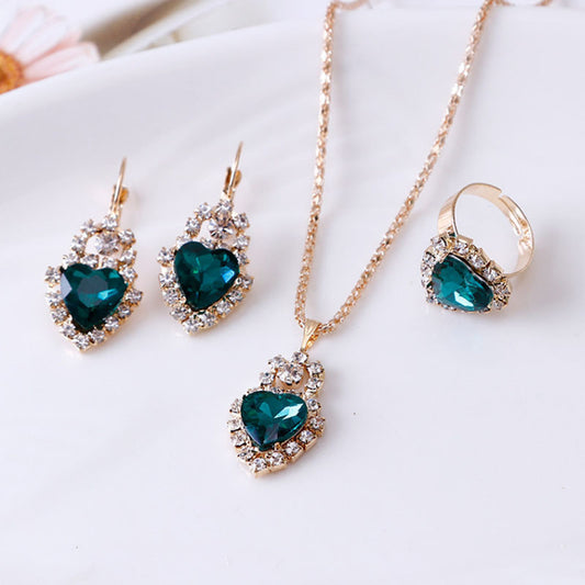 Stylish 3Sixty5 rhinestone jewelry set featuring heart-shaped earrings, necklace, and ring in teal and gold